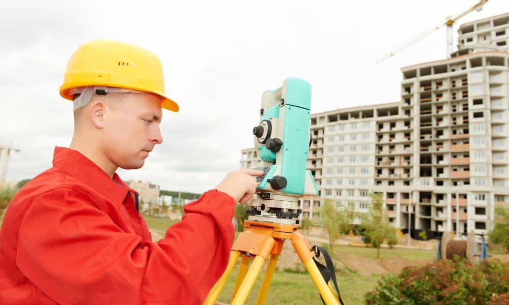 Surveyor in Houston using professional equipment for a topographic survey near a construction site
