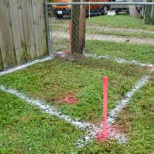  Wooden stakes with bright markers outlining construction site boundaries during a staking survey