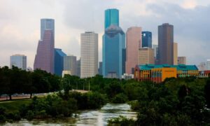 Houston skyline with rising water in the foreground symbolizing flood risk, land subsidence, and the need for an elevation certificate