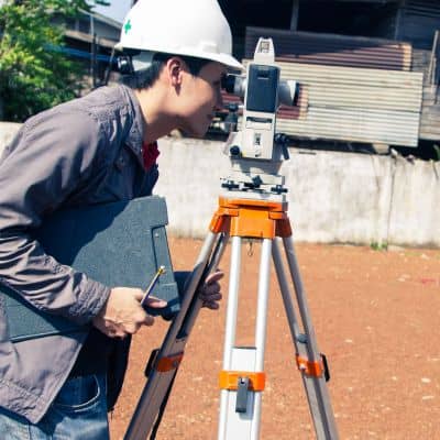 Survey professional at work, showing why homeowners search for a licensed land surveyor near me after storms