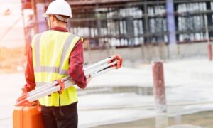 Construction surveyor verifying site elevations before foundation work begins