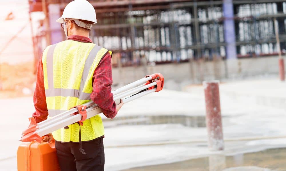 Construction surveyor verifying site elevations before foundation work begins